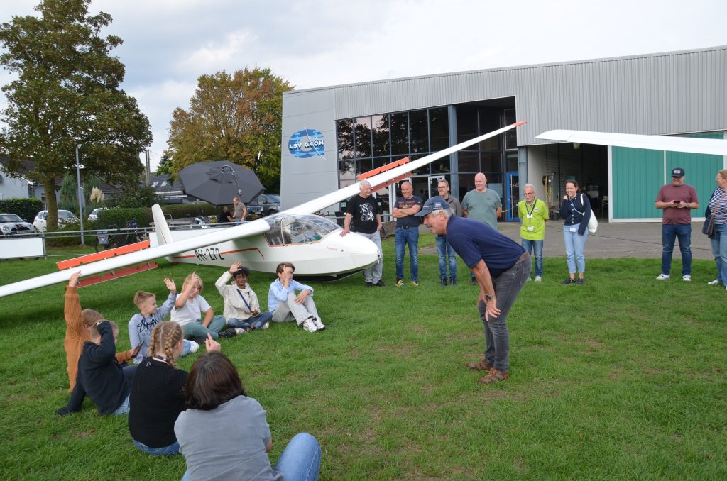 Kinder und Piloten des LSV Goch versammeln sich vor dem Segelflugzeug „Ameland“ zum Briefing