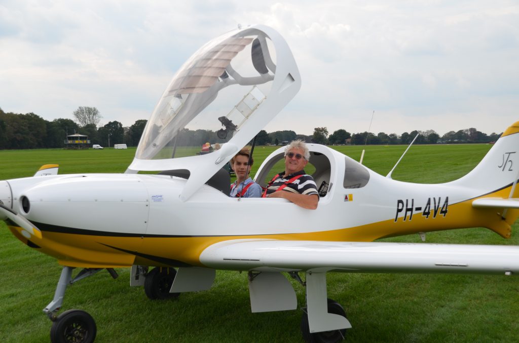 Vater und Sohn sitzen im Ultraleichtflugzeug PH-4V4 vor dem Start