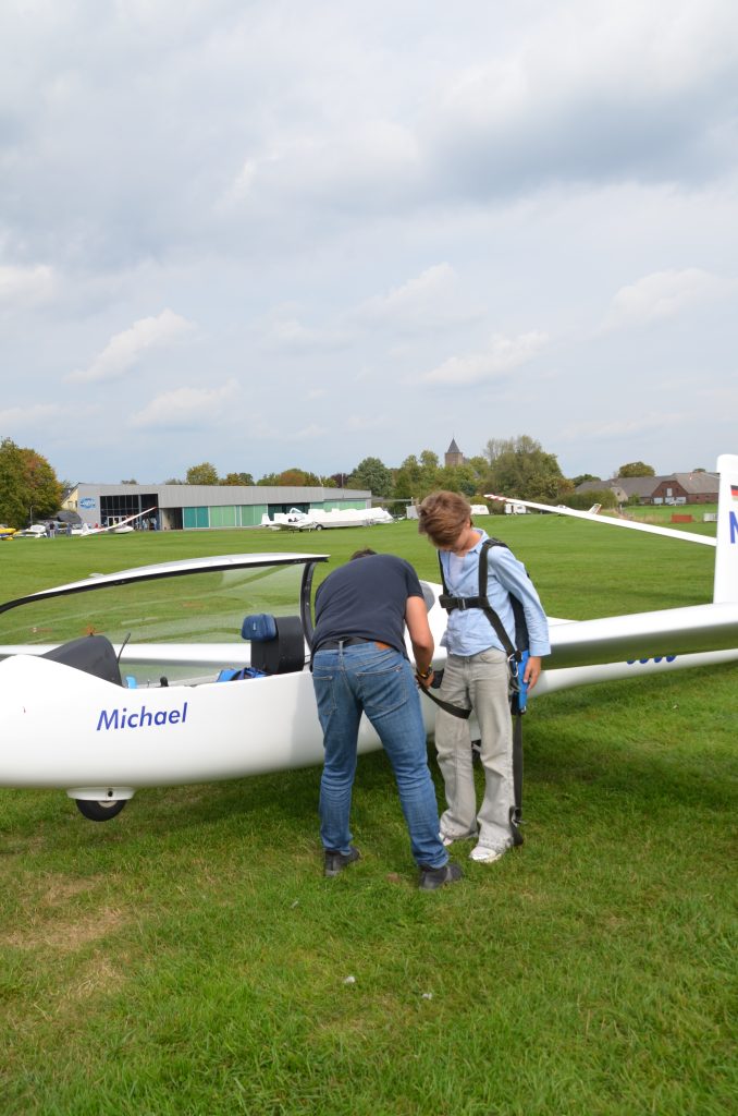 Ein Kind legt vor dem Segelflug den Fallschirm an