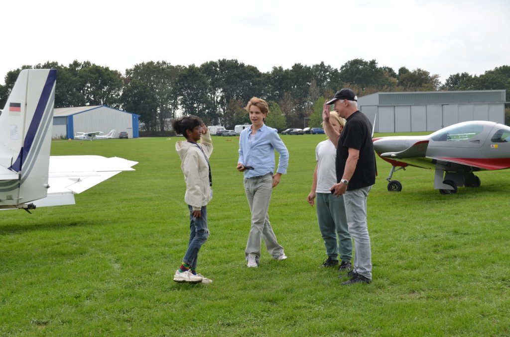 Kinder klatschen sich nach der Landung mit ihrem Piloten ab