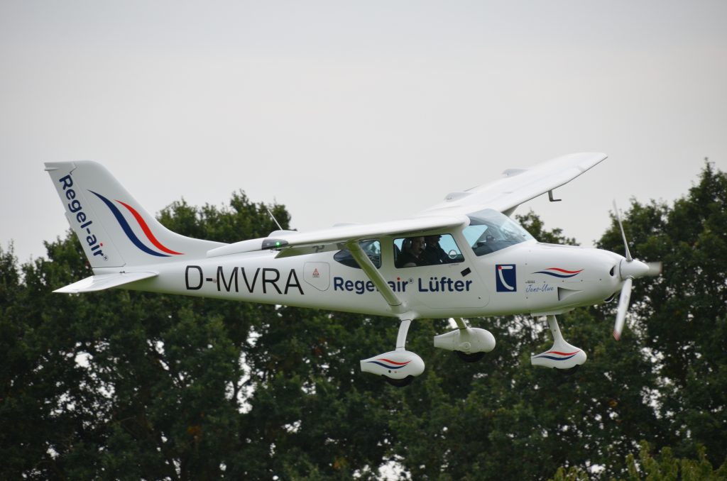 Ultraleichtflugzeug „Regel-air“ im Landeanflug vor Bäumen