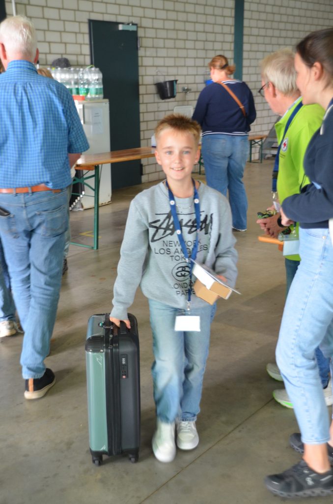 Junge trägt den Hauptpreis der Verlosung durch die Vereinshalle des LSV Goch