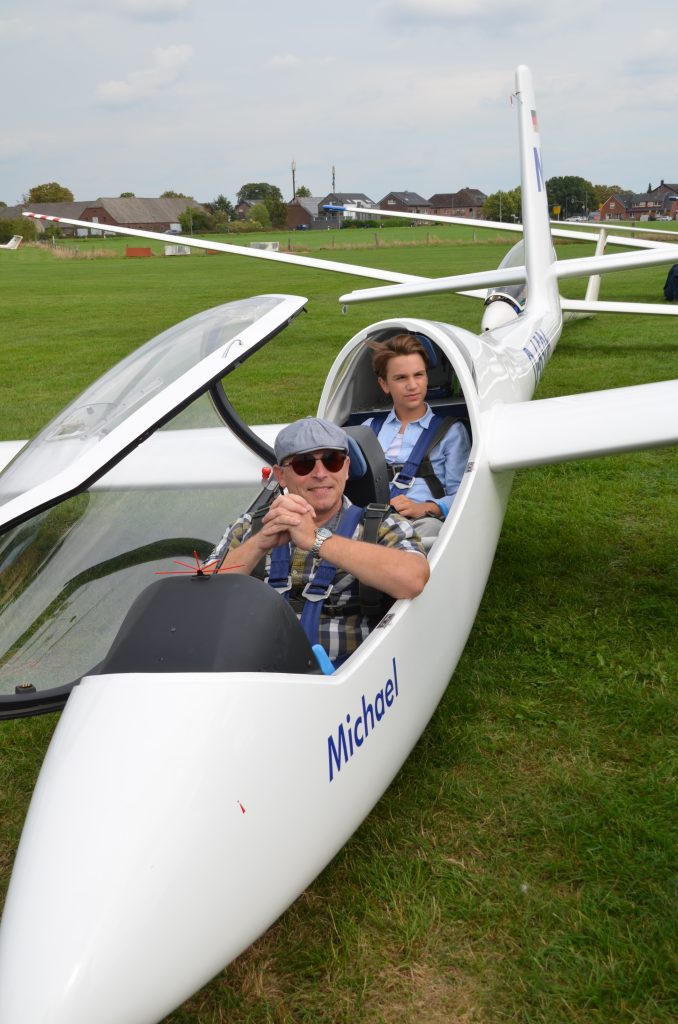 Pilot und Kind sitzen im Segelflugzeug „Michael“ vor dem Start