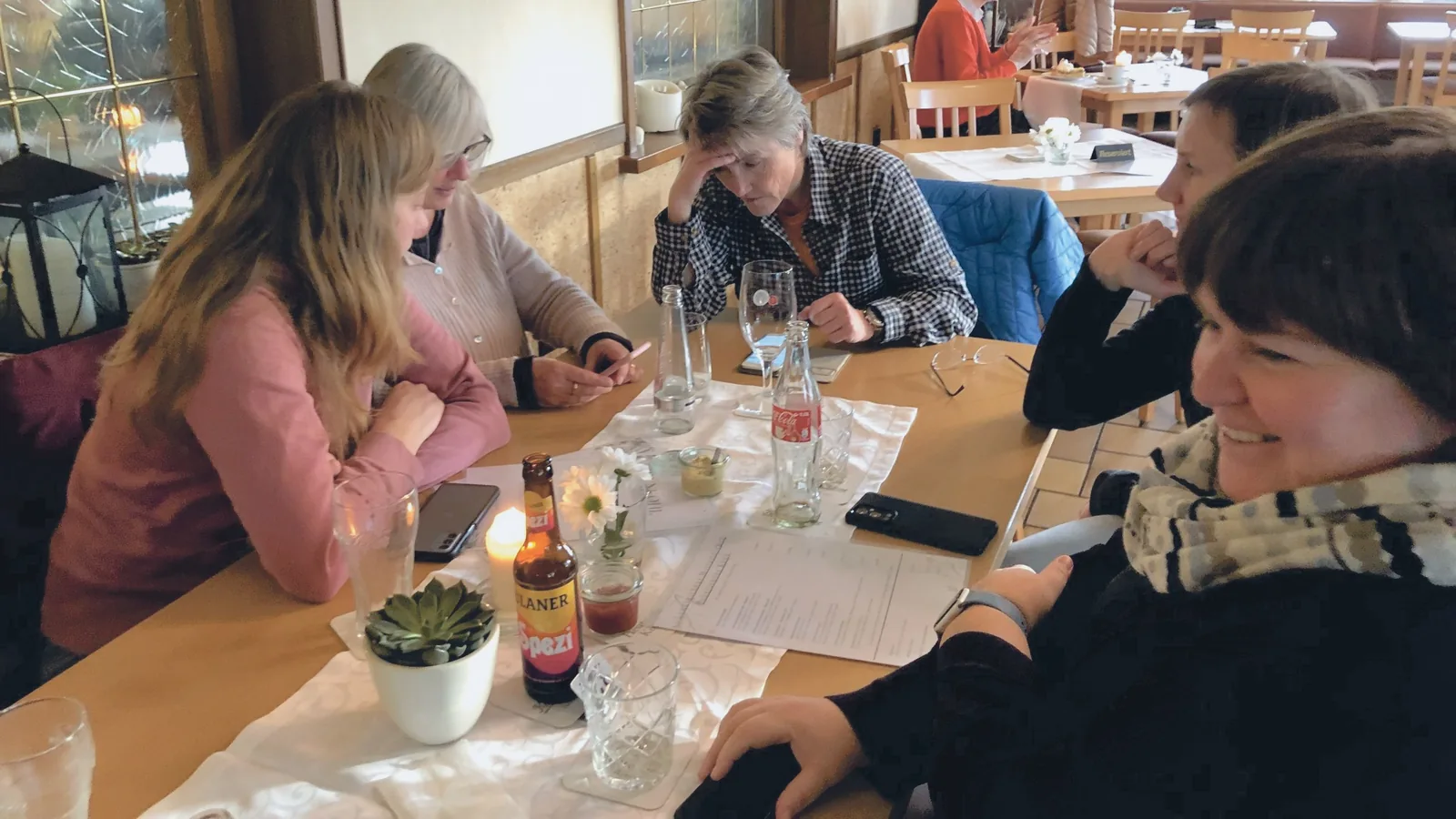 Frauen sitzen bei einem Workshop an einem Tisch und tauschen sich aus